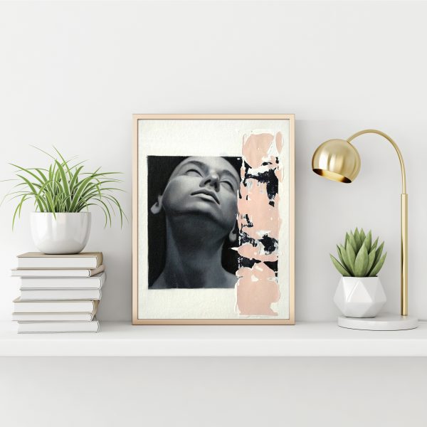 "Black and white serie 1" modern portrait with pink textured line with gold metal frame standing on the table with succulent plant, lamp and pile of books on empty white wall background.